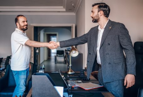 two men shaking hands in an office setting