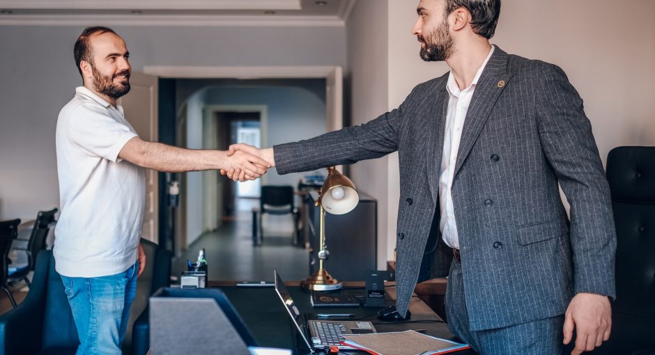 two men shaking hands in an office setting