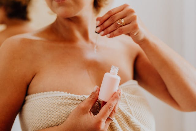 close-up-of-woman-applying-serum-on-body